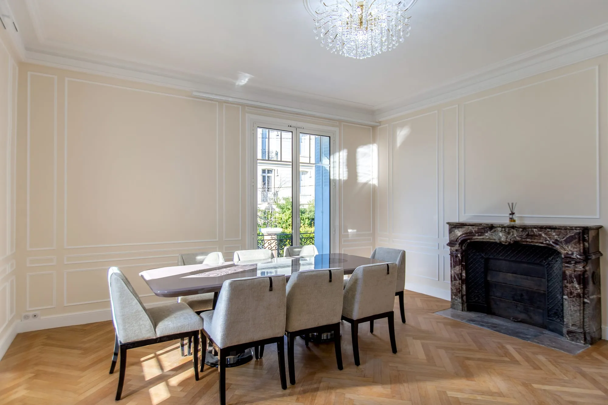 Salle à manger avec cheminée en marbre noir et parquet point de Hongrie